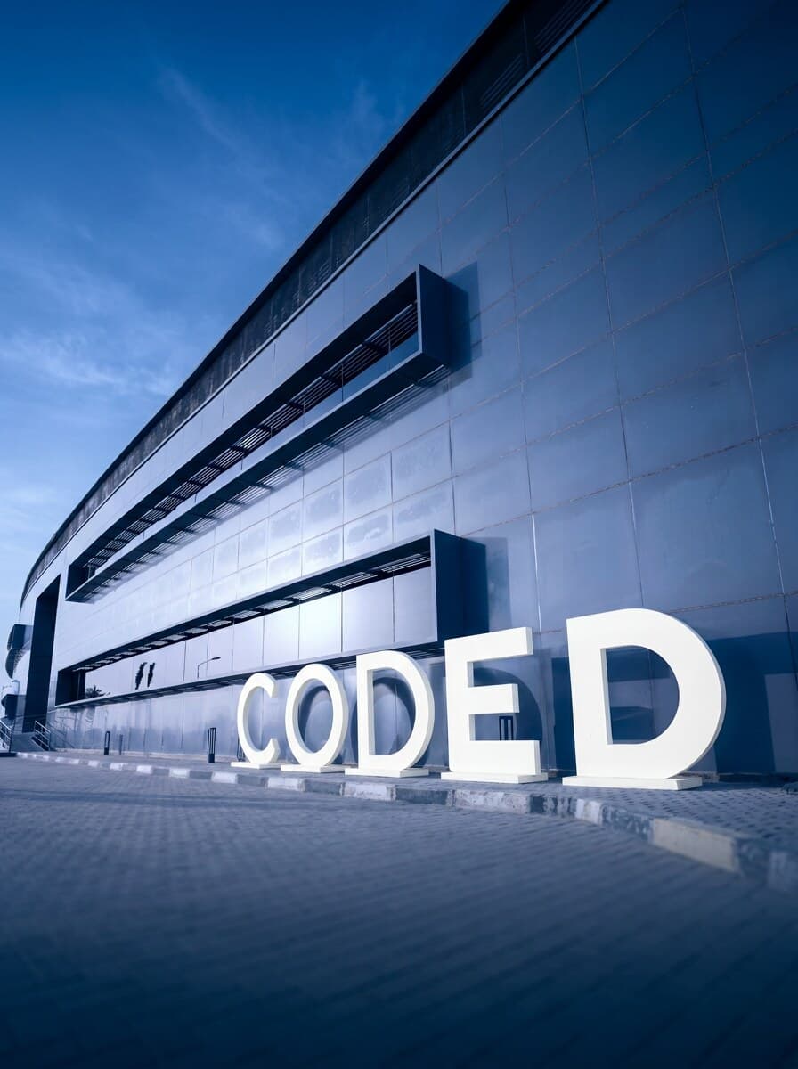 The CODED building at dusk with giant white CODED letters