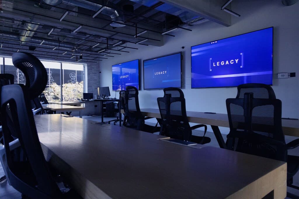 The LEGACY classroom at CODED with wall screens glowing blue